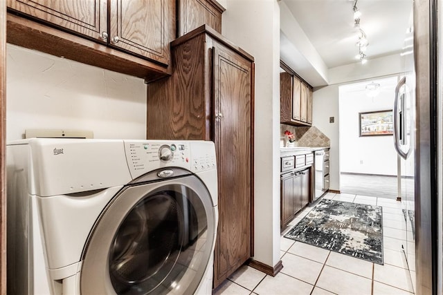 clothes washing area with light tile patterned floors and washer / dryer