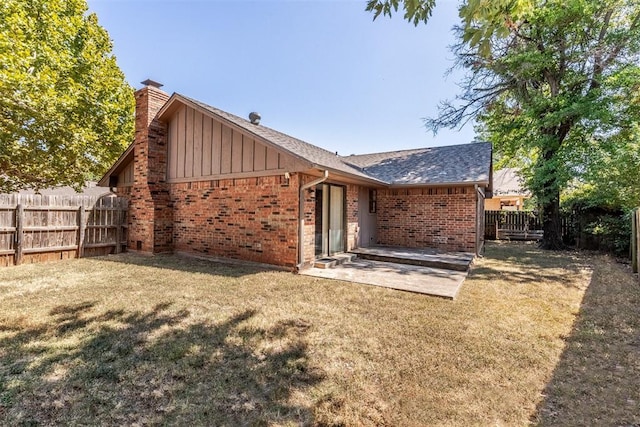 rear view of property featuring a lawn