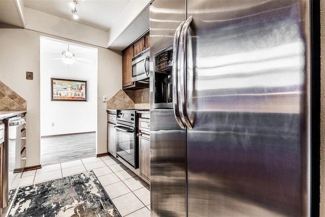 kitchen featuring backsplash, ceiling fan, light tile patterned floors, and stainless steel appliances