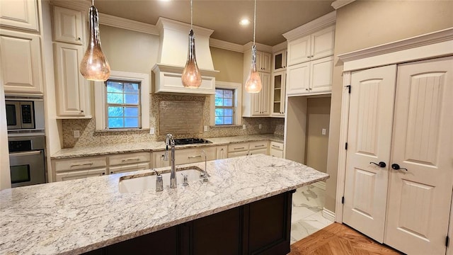 kitchen featuring pendant lighting, sink, light stone countertops, appliances with stainless steel finishes, and tasteful backsplash