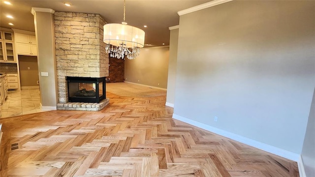 unfurnished living room featuring a chandelier, light parquet flooring, a fireplace, and ornamental molding