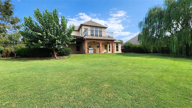 exterior space featuring a balcony and a front yard