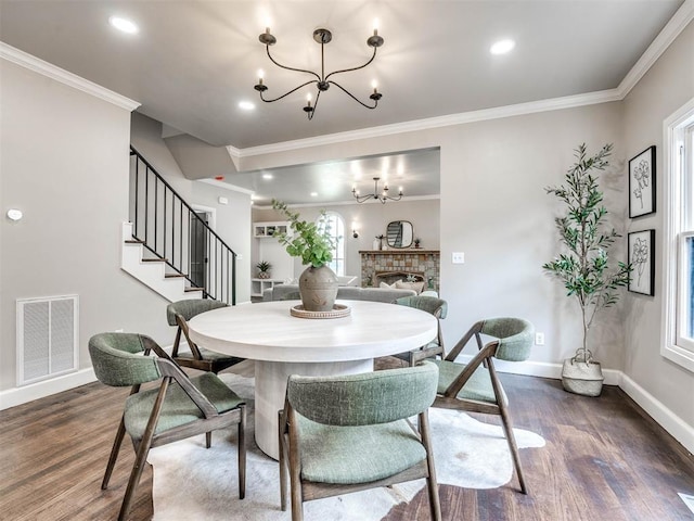 dining room featuring an inviting chandelier, dark wood-type flooring, and ornamental molding