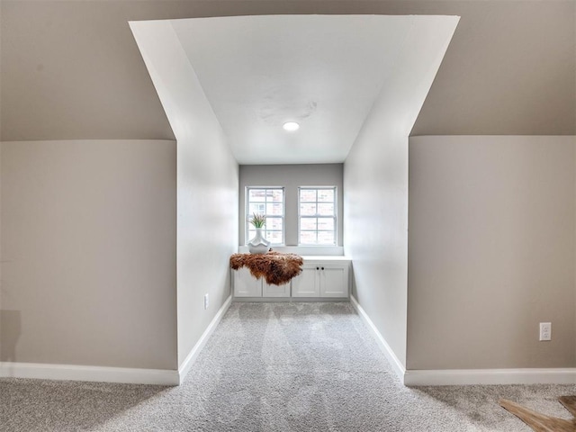 hallway featuring carpet and lofted ceiling