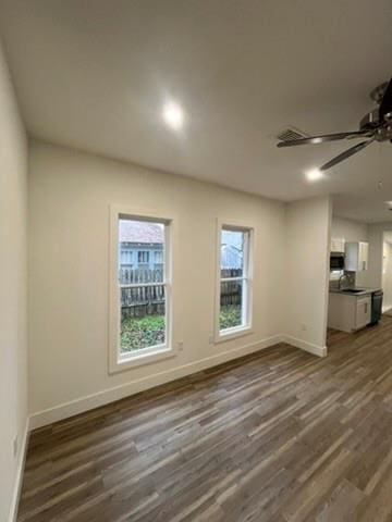 unfurnished living room with ceiling fan and dark wood-type flooring