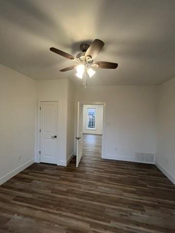 empty room with dark wood-type flooring and ceiling fan