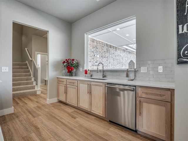 kitchen featuring backsplash, light brown cabinetry, dishwasher, and sink