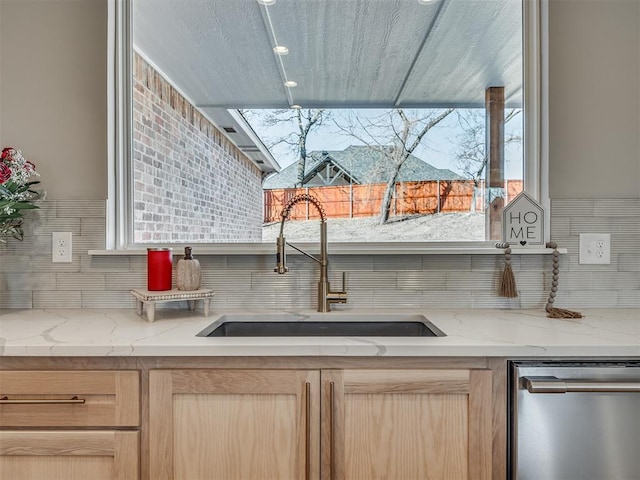 kitchen with light brown cabinetry, dishwasher, sink, and a healthy amount of sunlight