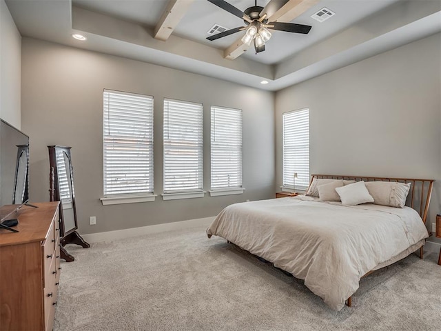 carpeted bedroom featuring a raised ceiling and ceiling fan