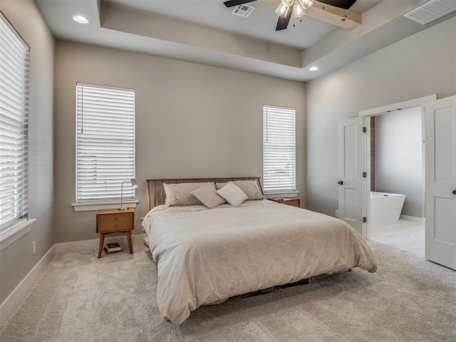 carpeted bedroom with a tray ceiling and ceiling fan