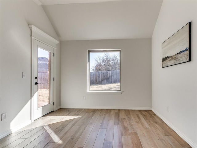 unfurnished room with light hardwood / wood-style floors and vaulted ceiling