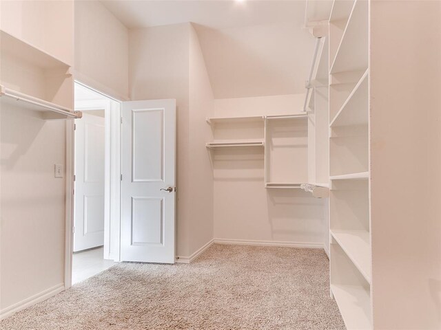 walk in closet featuring light carpet