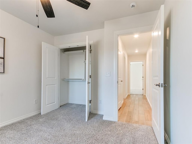 unfurnished bedroom with a closet, ceiling fan, and light colored carpet