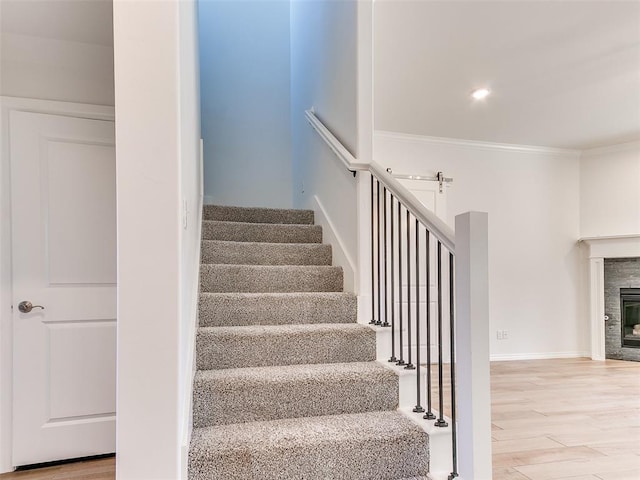 staircase featuring hardwood / wood-style flooring and crown molding