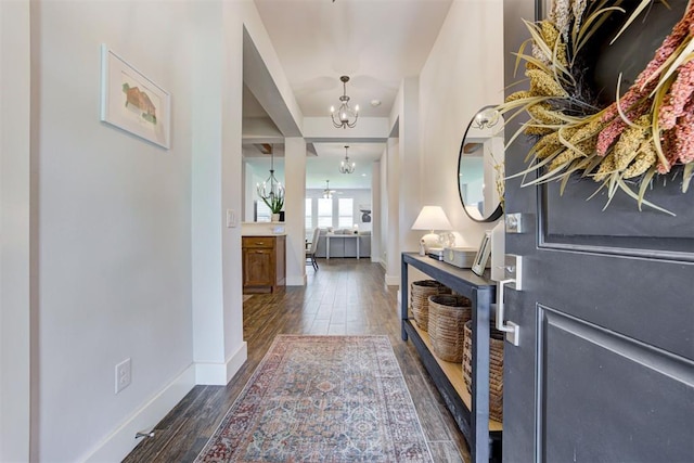 foyer with dark wood-type flooring and a notable chandelier