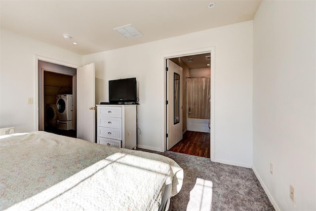 carpeted bedroom featuring connected bathroom, visible vents, separate washer and dryer, baseboards, and a spacious closet