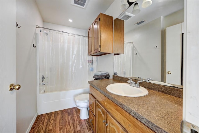bathroom with toilet, visible vents, wood finished floors, and vanity