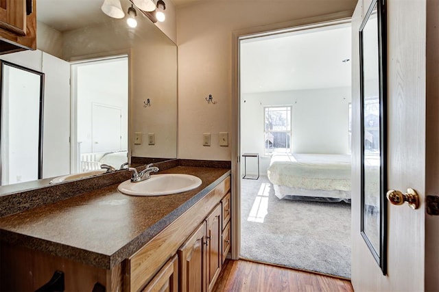 bathroom with vanity, ensuite bath, and wood finished floors