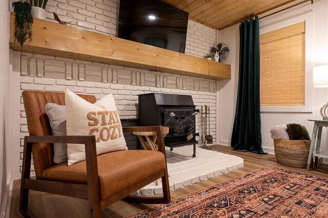 sitting room with a wood stove, wood ceiling, and hardwood / wood-style flooring