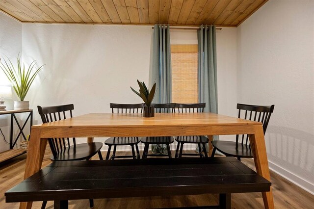 dining space featuring hardwood / wood-style flooring, wood ceiling, and crown molding