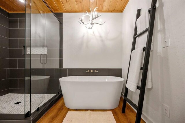 bathroom with hardwood / wood-style floors, separate shower and tub, wood ceiling, and an inviting chandelier