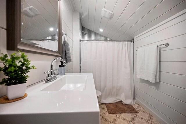 bathroom featuring a shower with curtain, toilet, lofted ceiling, and sink