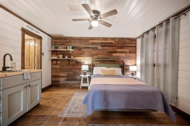 bedroom with wooden walls, sink, ceiling fan, and wooden ceiling