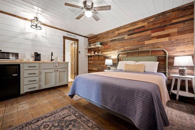 bedroom with ceiling fan, wood walls, wood ceiling, and dark hardwood / wood-style floors