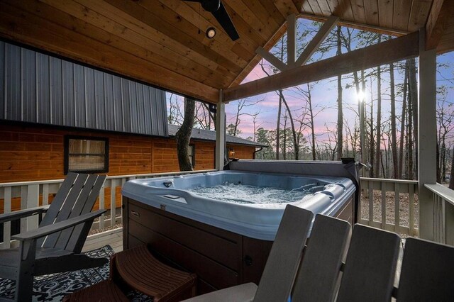 deck at dusk with a gazebo, ceiling fan, and a hot tub