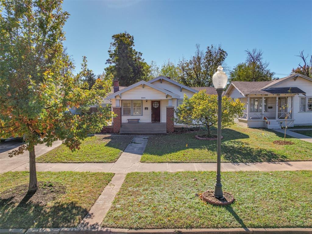 bungalow-style house with a porch and a front lawn