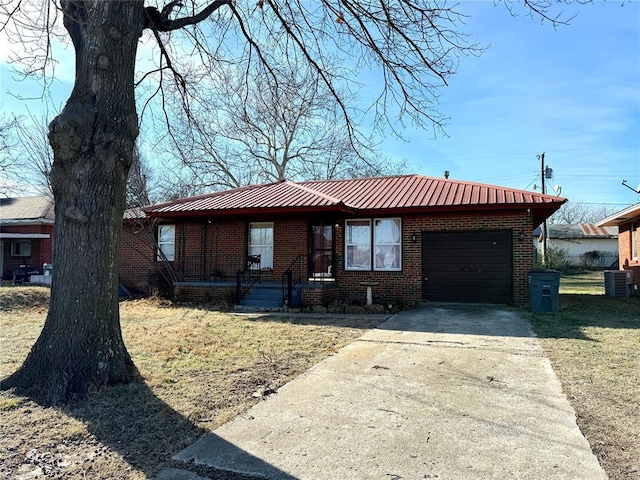 ranch-style home with central AC, a front lawn, and a garage