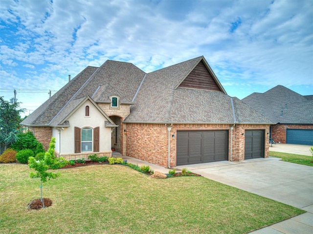 french provincial home featuring a garage and a front yard