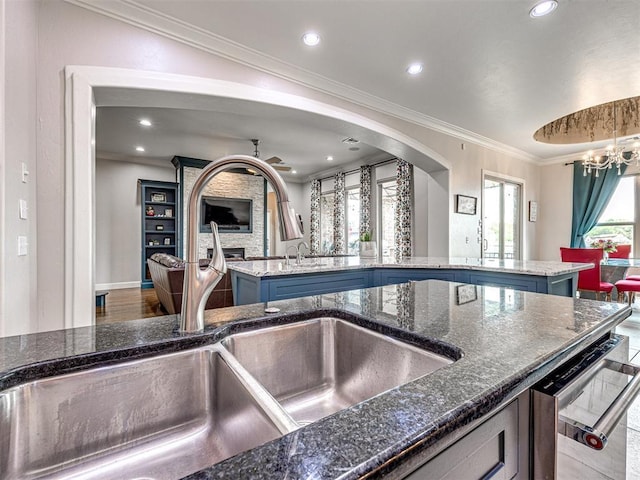 kitchen featuring a center island, dark stone countertops, sink, a notable chandelier, and crown molding