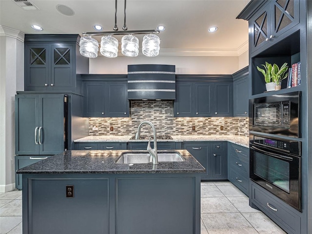 kitchen with black appliances, a kitchen island with sink, decorative light fixtures, dark stone counters, and wall chimney exhaust hood