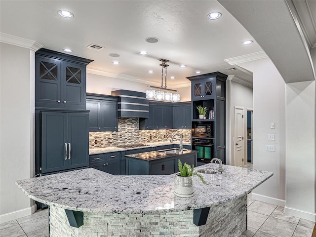 kitchen featuring a large island, decorative light fixtures, light stone countertops, blue cabinets, and black appliances