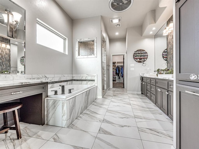 bathroom with tiled bath and vanity