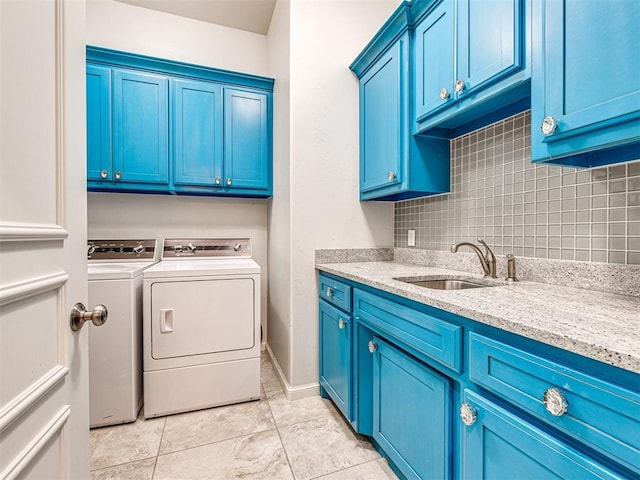 laundry area featuring cabinets, sink, washer and clothes dryer, and light tile patterned floors