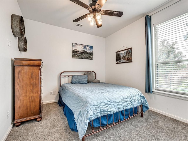 carpeted bedroom featuring ceiling fan and multiple windows