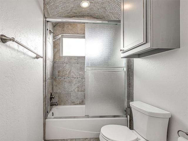 bathroom featuring shower / bath combination with glass door and toilet