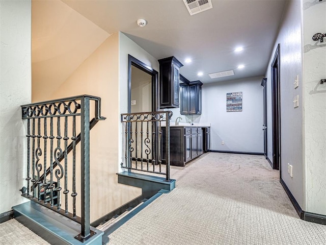 hall with sink and carpet