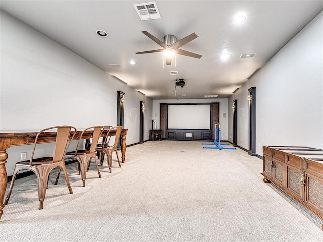 home theater room with light colored carpet and ceiling fan