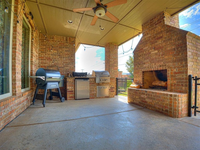 view of patio featuring area for grilling, exterior kitchen, and an outdoor brick fireplace