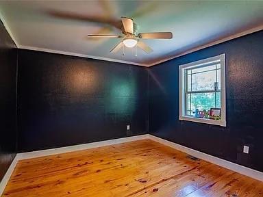 unfurnished room featuring hardwood / wood-style floors, ceiling fan, and ornamental molding