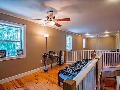 interior space with ceiling fan, crown molding, and wood-type flooring