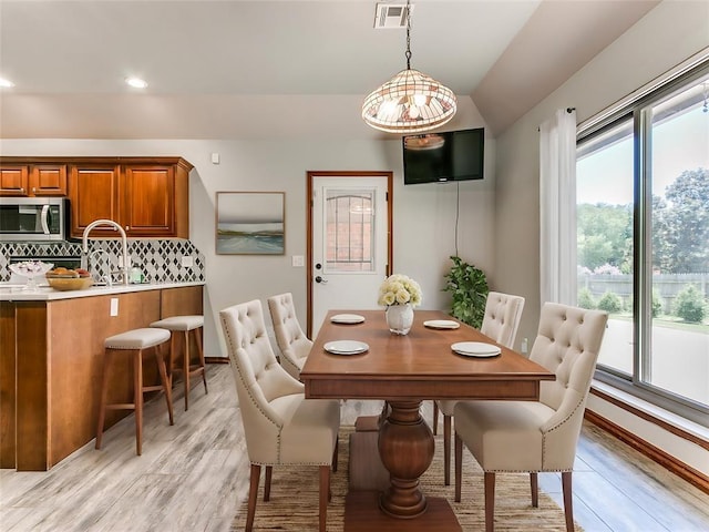 dining room featuring light hardwood / wood-style floors and lofted ceiling