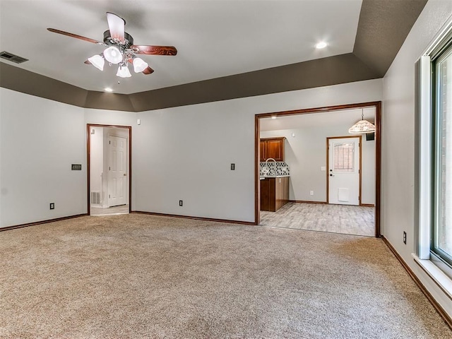 unfurnished room featuring light colored carpet, plenty of natural light, and ceiling fan