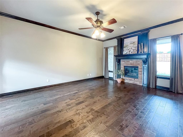 unfurnished living room featuring a fireplace, dark hardwood / wood-style floors, ceiling fan, and crown molding