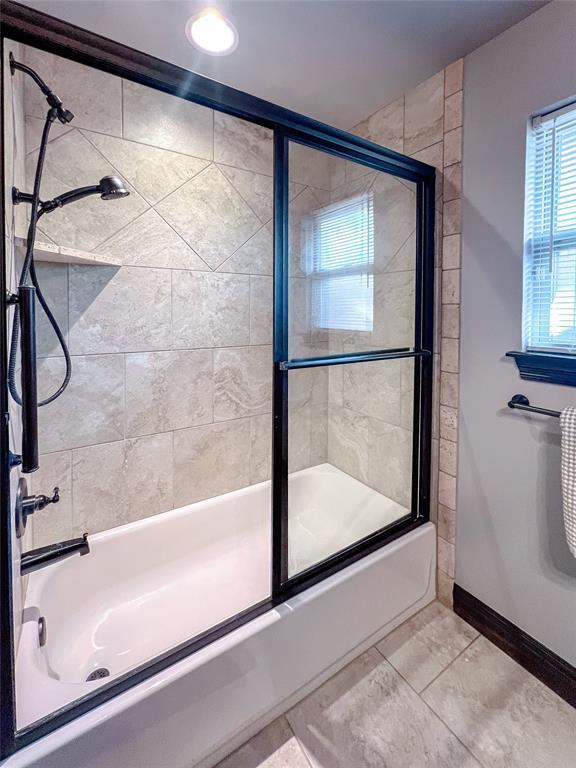 bathroom with shower / bath combination with glass door