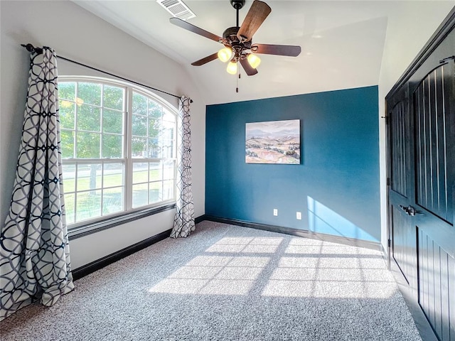 unfurnished room featuring ceiling fan, light colored carpet, and vaulted ceiling