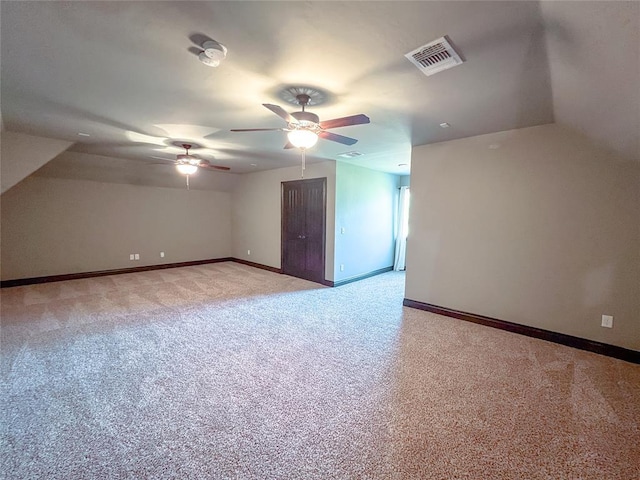 additional living space with light colored carpet and ceiling fan